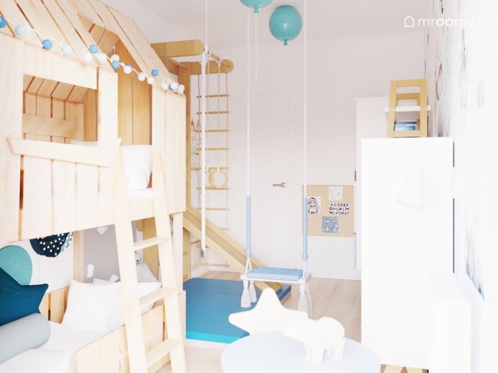 Biały pokój dla malutkiego chłopca a w nim drewniana antresola z miejscem do spania drabinka gimnastyczna ze zjeżdżalnią huśtawka wisząca oraz niebieskie lampy balony