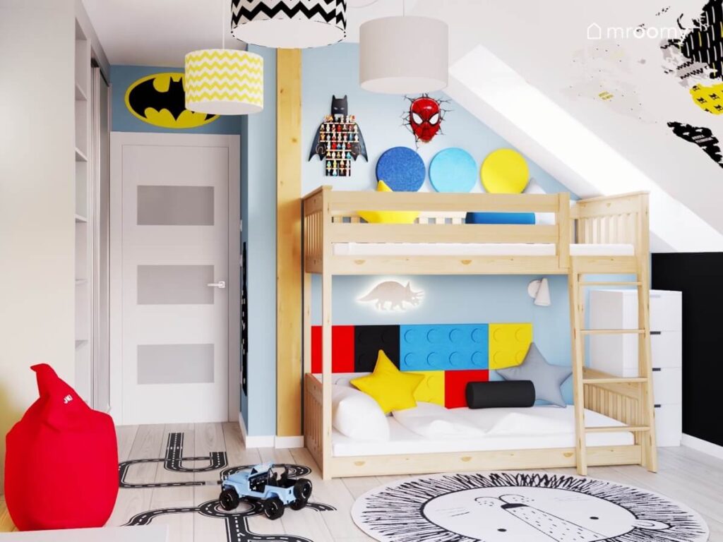Biało niebieski poddaszowy pokój dla chłopca z drewnianym łóżkiem piętrowym kolorowymi panelami ściennymi oraz motywami superbohaterów