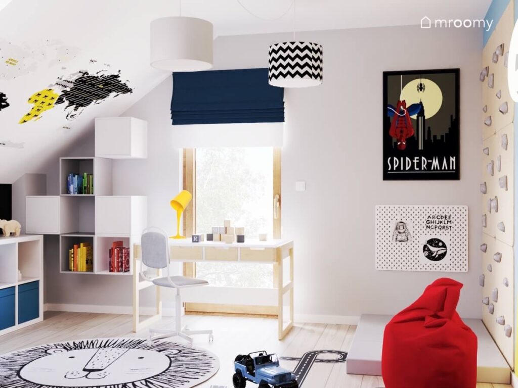 Jasny poddaszowy pokój dla chłopca z biało drewnianymi meblami dywanem z lwem mapą świata na skosie oraz plakatem ze Spidermanem