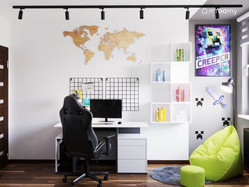 Strefa nauki w pokoju dziewięciolatka w niej biurko z fotelem gamingowym a na ścianie organizery szafki mapa świata i motywy z Minecrafta