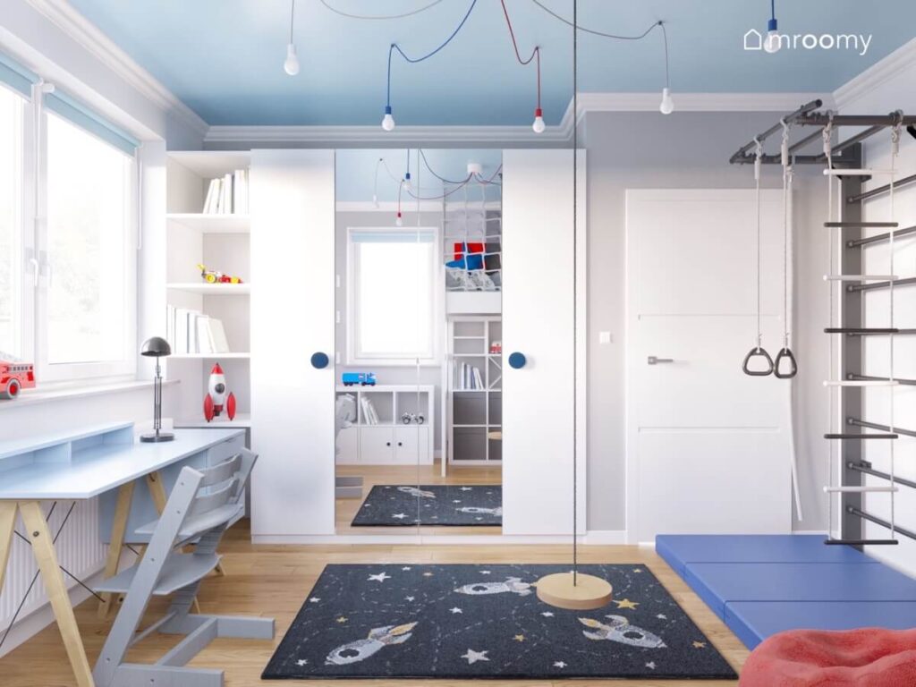 Szaro niebiesko biały pokój dla chłopca a w nim duża szafa z lustrzanymi frontami kosmiczny dywan oraz huśtawka wisząca w formie talerza