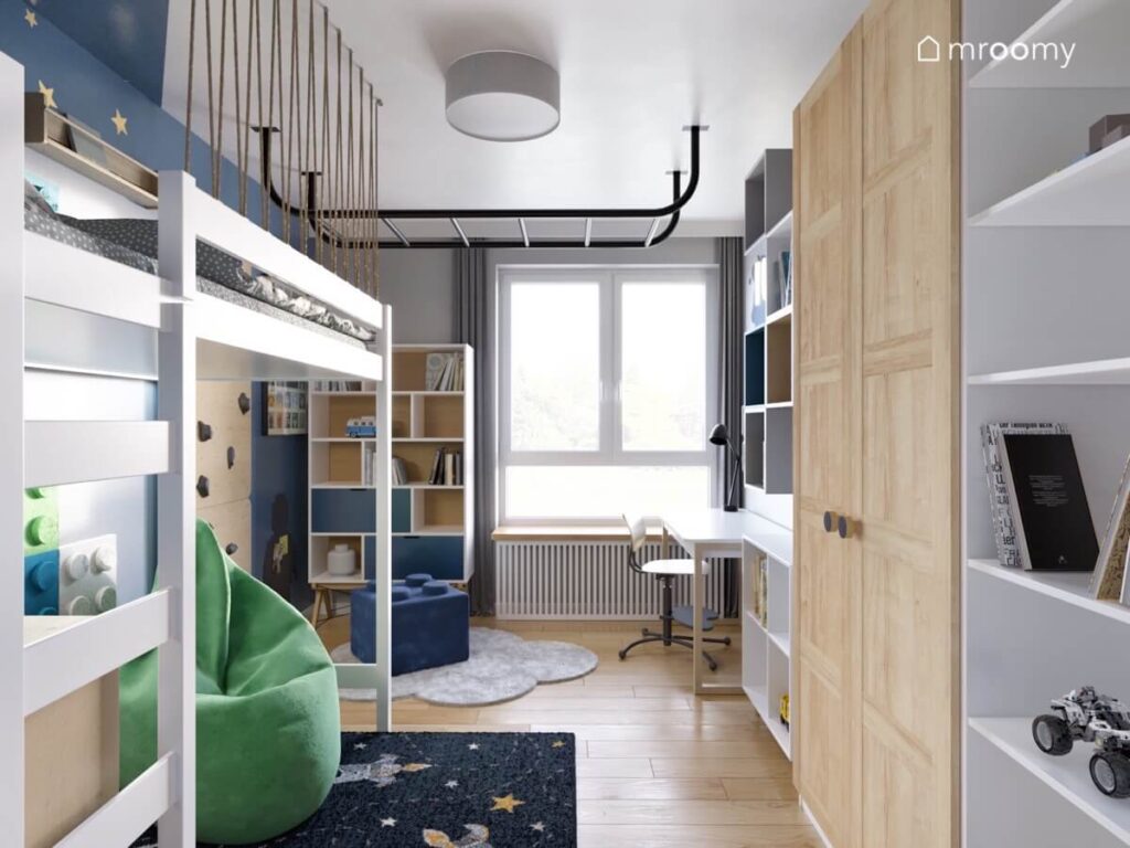 Szary pokój dla kilkuletniego chłopca a w nim antresola drewniane meble duża zielona pufa oraz drabinka na suficie