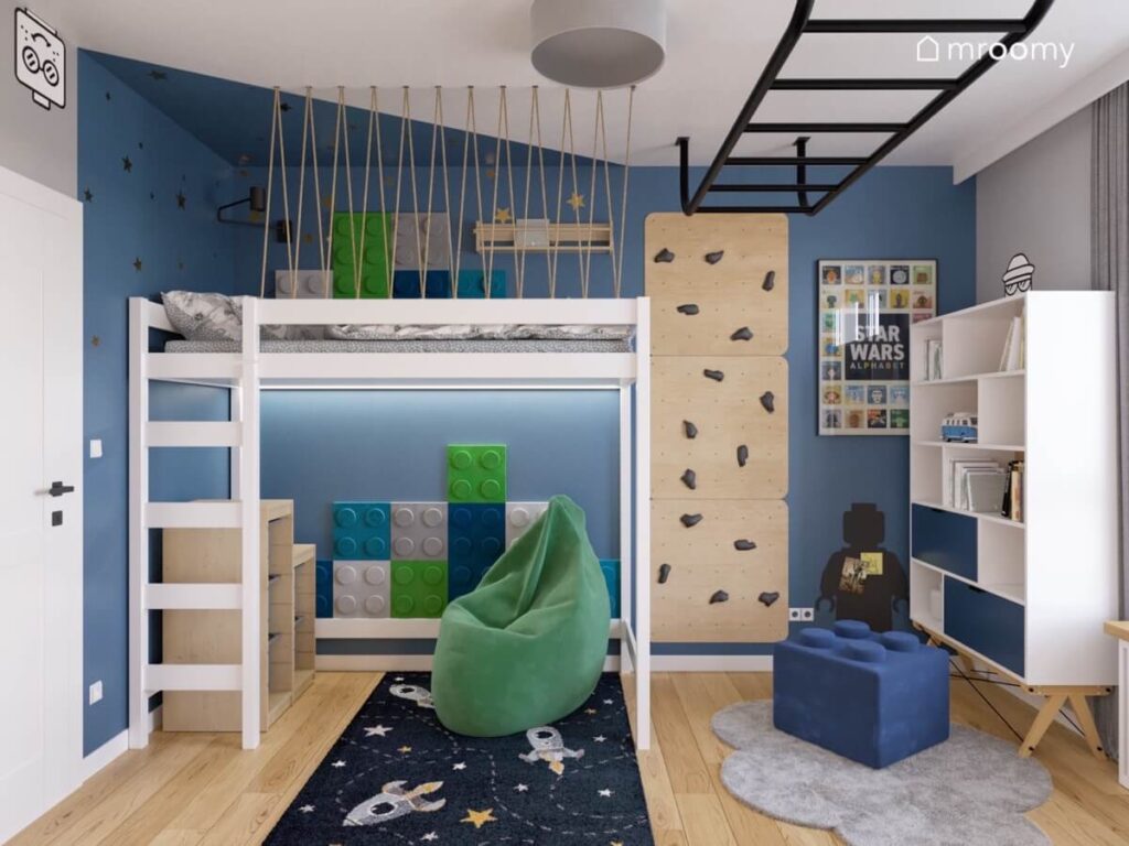 Granatowo szary pokój dla chłopca a w nim antresola ścianka wspinaczkowa drabinka na suficie zielona pufa i kosmiczny dywan