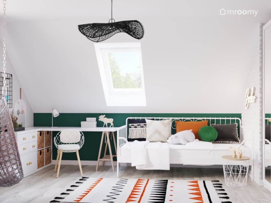 Biało zielony pokój nastolatki na poddaszu z białym łóżkiem i biurkiem dużą czarną lampą sufitową i wzorzystym dywanem