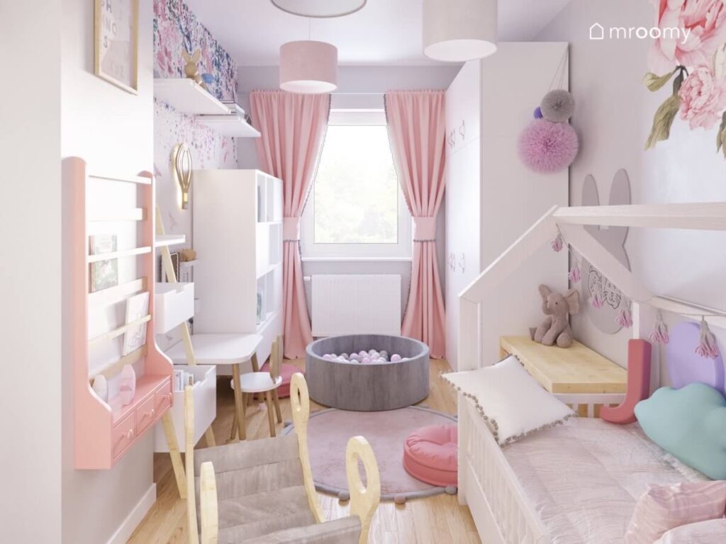Jasny pokój dla dwuletniej dziewczynki a w nim białe łóżko domek i inne białe meble różowe dodatki oraz bujak i basen z kulkami