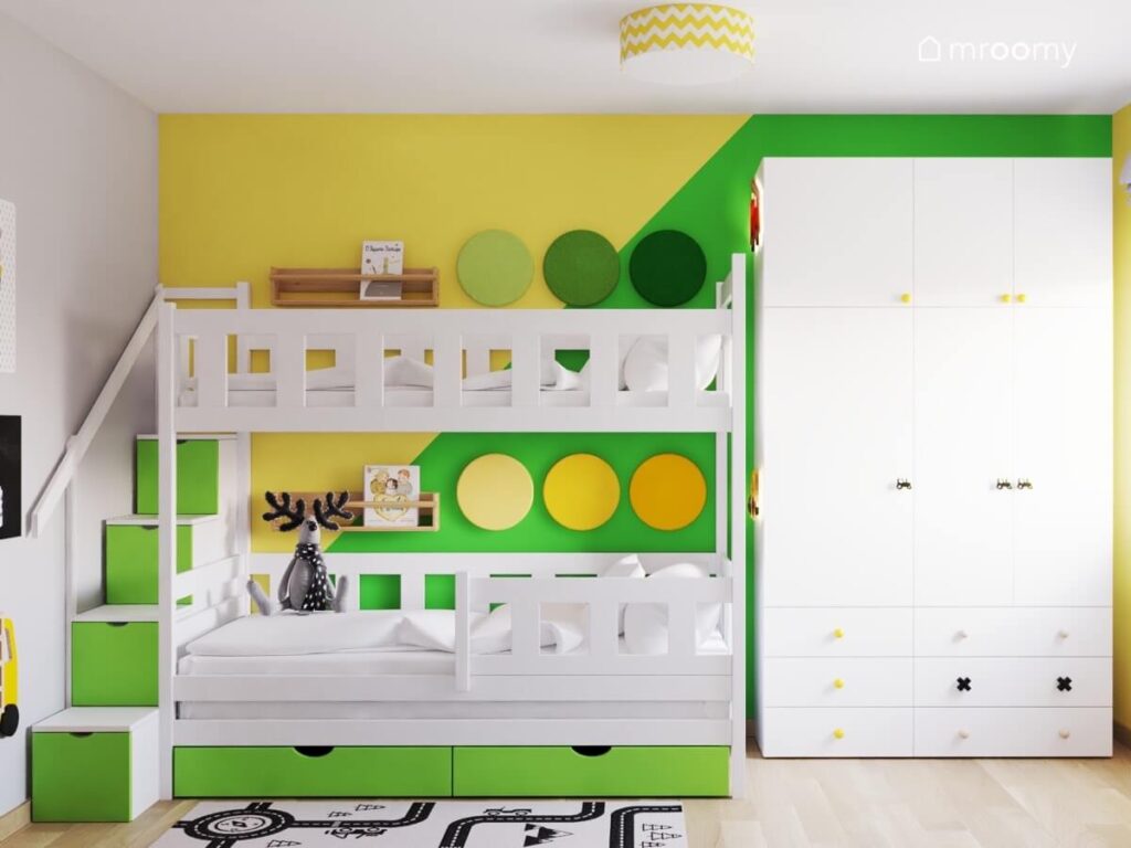 Żółto zielona strefa spania w pokoju dwóch kilkuletnich chłopców a w niej łóżko piętrowe z półeczkami na książki oraz panelami ściennymi oraz ze schowkami w schodkach
