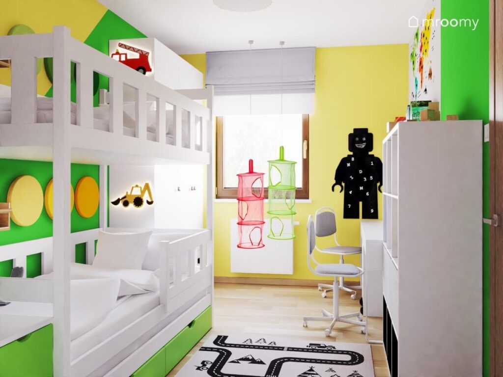 Biało żółto zielony pokój dwóch chłopców w wieku przedszkolnym a w nim białe meble oraz tablica kredowa w kształcie ludzika Lego