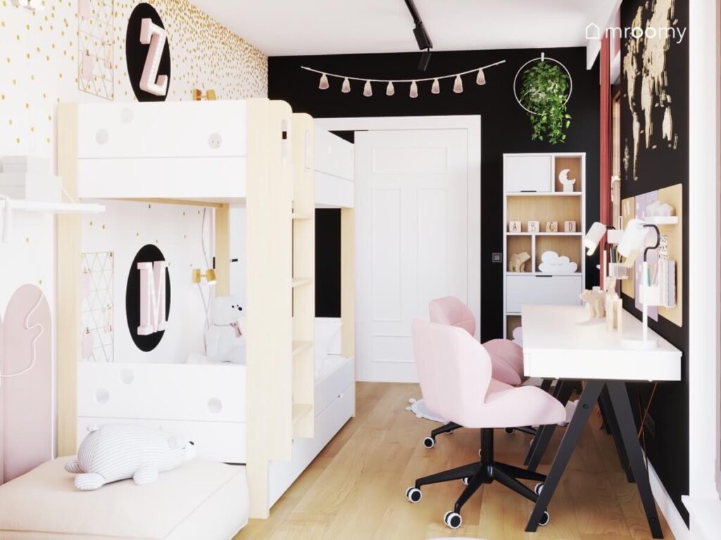 Biało drewniane łózko piętrowe w biało czarnym pokoju dwóch dziewczynek a oprócz tego biurka na czarnych nogach różowe fotele a na ścianie girlanda pomponów i kwietnik