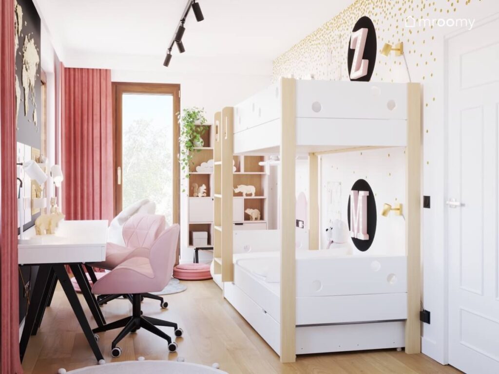 Jasny pokój dla dwóch sióstr a w nim łóżko piętrowe pierwsze litery imion dziewczynek na ścianie oraz białe biurka z różowymi krzesłami
