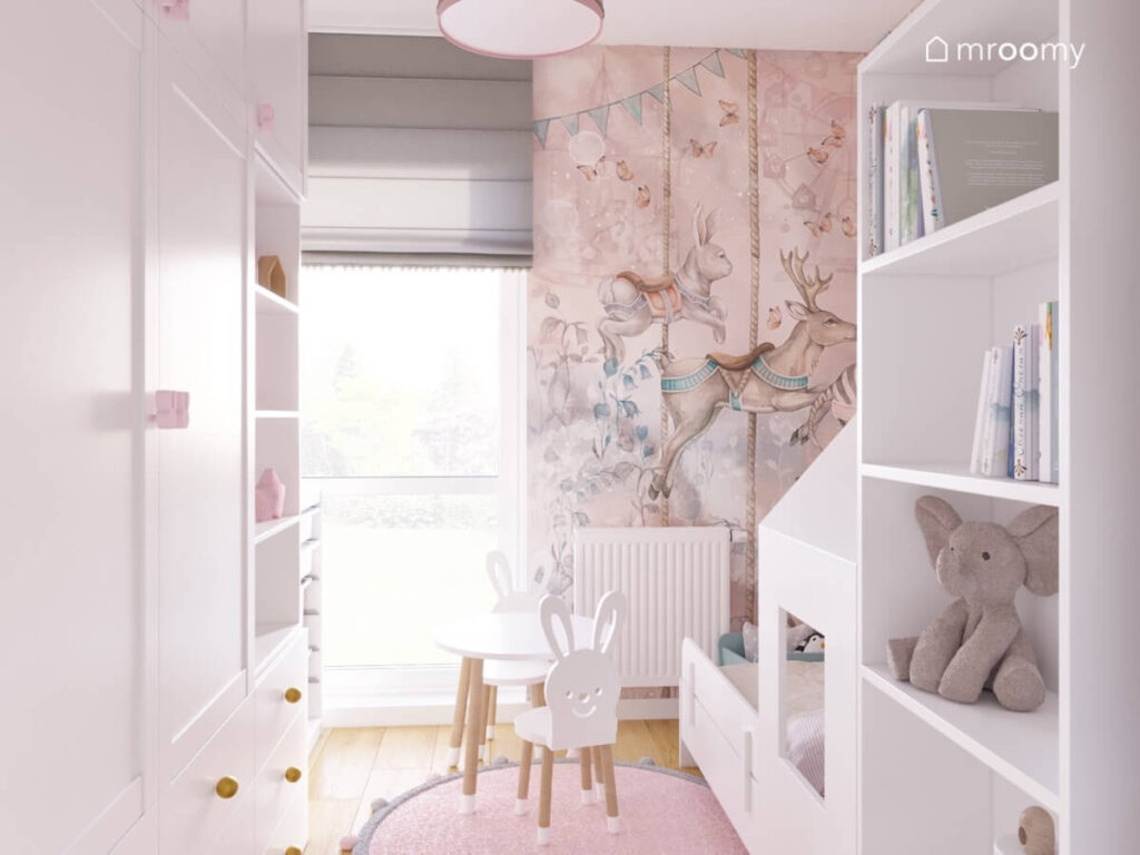 Jasny pokój dla dwuletniej dziewczynki w nim białe meble bajkowa tapeta oraz krzesełka z oparciami w kształcie królików