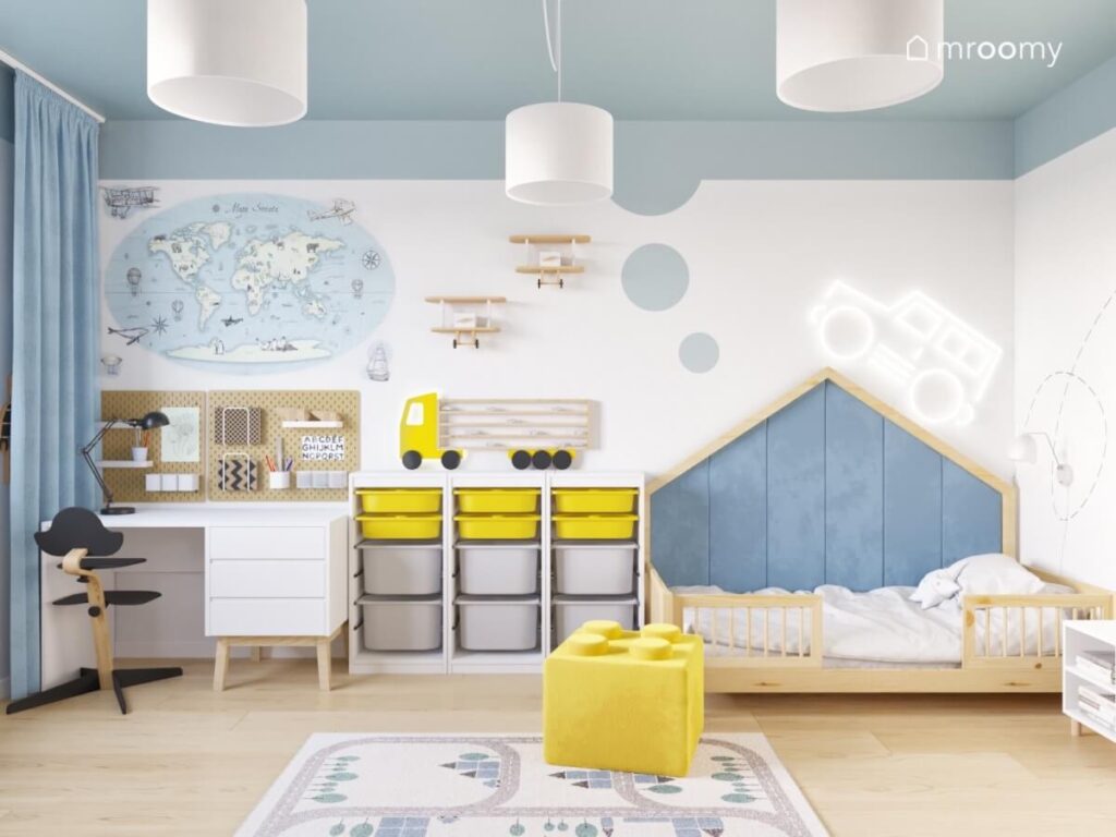 Biały pokój dla chłopca z niebieskim sufitem drewnianym łóżkiem domkiem oraz białymi meblami i żółtymi dodatkami