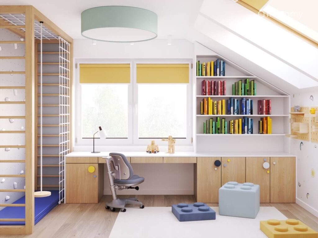 Przytulny poddaszowy pokój dla chłopca a w nim biało drewniane meble i kolorowe pufki klocki a na suficie duży plafon