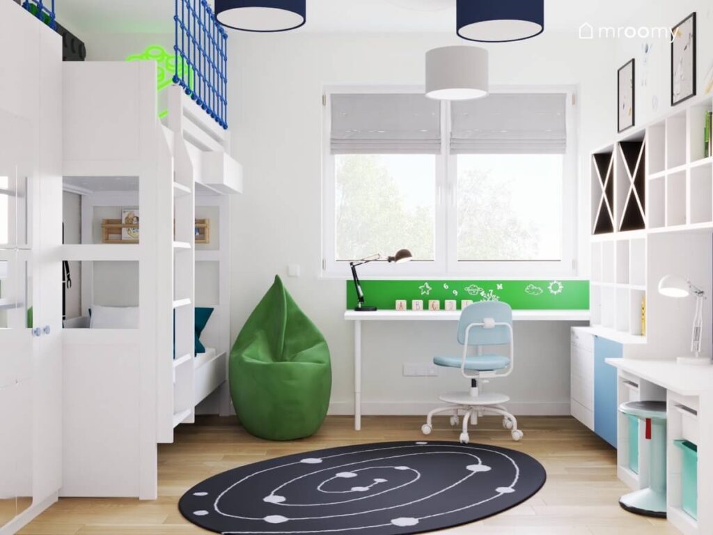 Biały pokój dla chłopca z białymi meblami i zielonymi dodatkami a także galaktycznym dywanem i granatowymi lampami