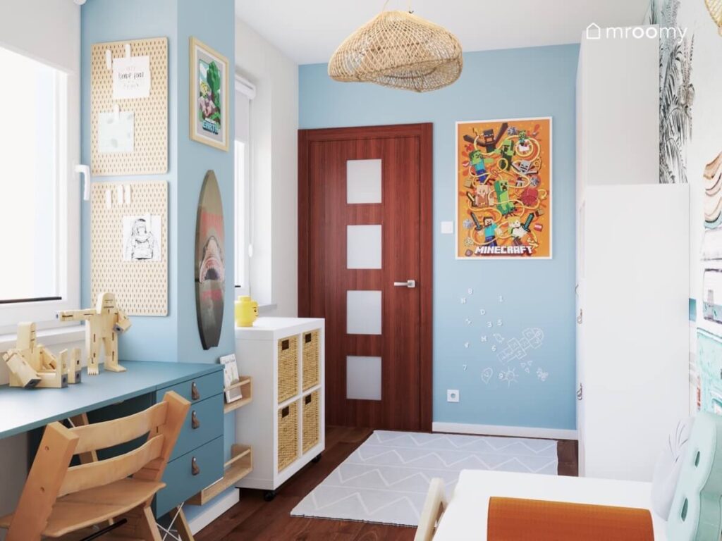 Niebiesko biały pokój dla chłopca z białymi meblami obrazkami z Minecrafta oraz wiklinową lampą sufitową