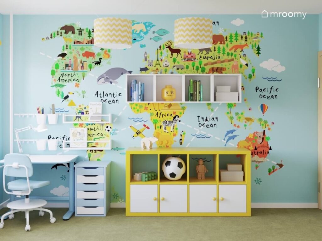 Ściana z kolorową naklejką mapa świata a na niej niska żółta szafka oraz szafki ścienne w pokoju dla chłopców