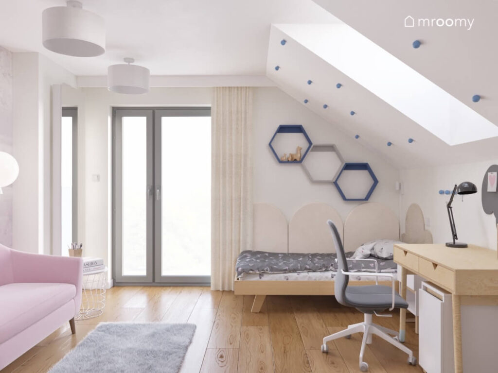 Biały poddaszowy pokój dla dziewczynki z drewnianym łóżkiem szarym dywanem oraz półkami w kształcie heksagonów