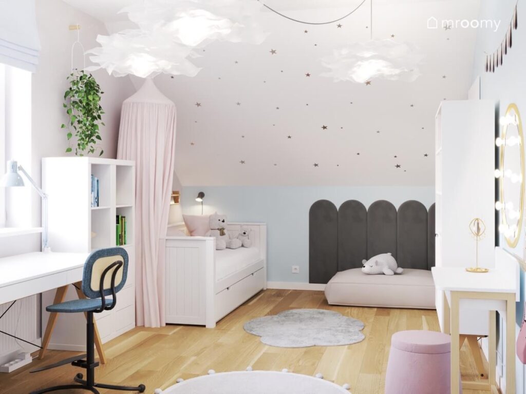 Jasny pokój dla dziewczynki na poddaszu a w nim biało drewniane meble łóżko ozdobione baldachimem i ciemne panele w formie płotku