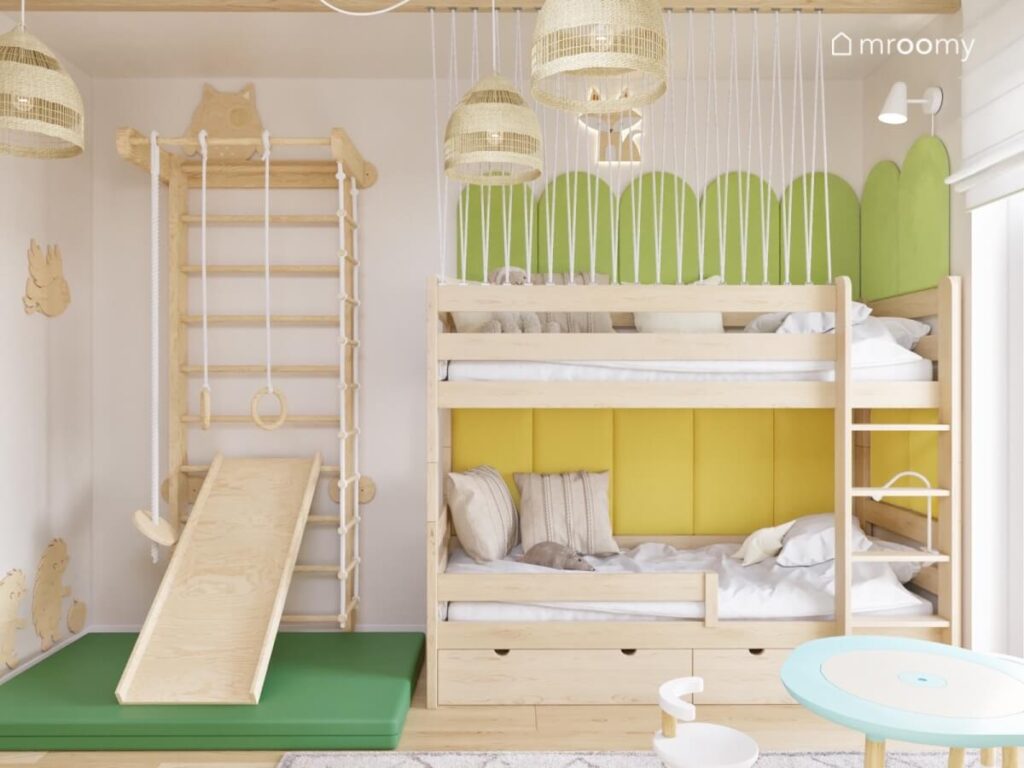 Drewniana drabinka gimnastyczna ze zjeżdżalnią a obok drewniane łóżko piętrowe uzupełnione zielonymi i żółtymi panelami w pokoju dla rodzeństwa