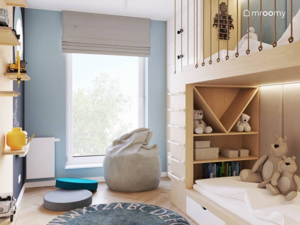 Biało niebieski pokój dla rodzeństwa z drewnianą antresolą oraz szarymi i niebieskimi pufami