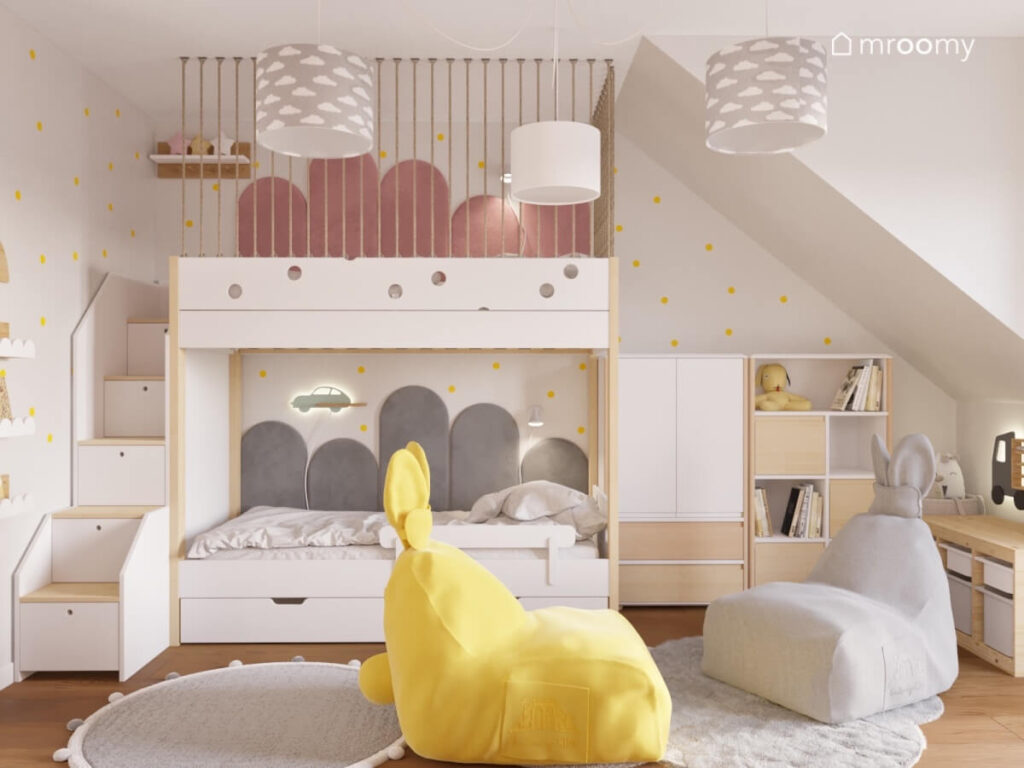 Łóżko piętrowe z panelami ściennymi żółte kropki na ścianie oraz uszaste pufy w poddaszowym pokoju dla rodzeństwa