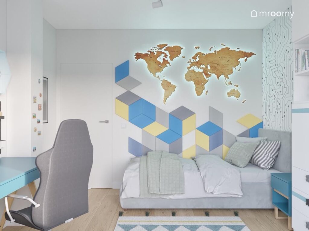 Strefa spania w szarym pokoju chłopca a w niej szare tapicerowane łóżko a na ścianie drewniana mapa świata i mozaika z kolorowych paneli ściennych
