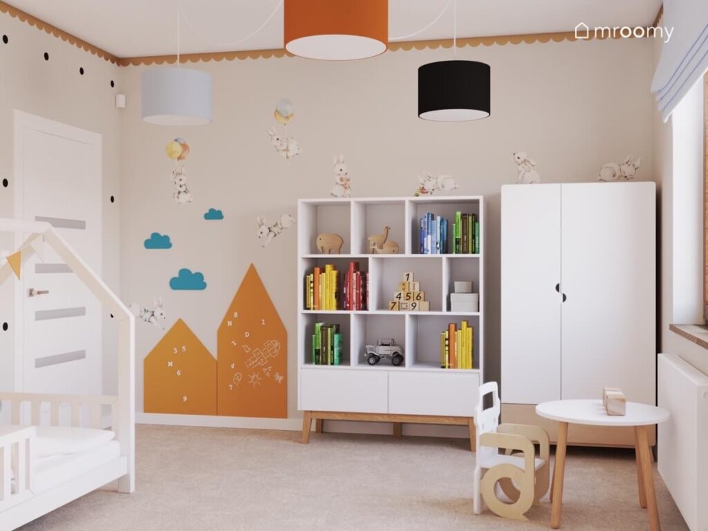 Beżowy pokój dla małego chłopca z białą szafą i regałem oraz pomarańczowymi tablicami kredowymi i naklejkami w kształcie królików