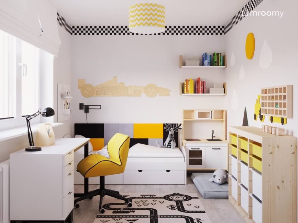 Jasny pokój dla chłopca z białymi meblami i żółtymi dodatkami drewnianą wyścigówką nad łóżkiem oraz flagą w szachownicę i sufitu