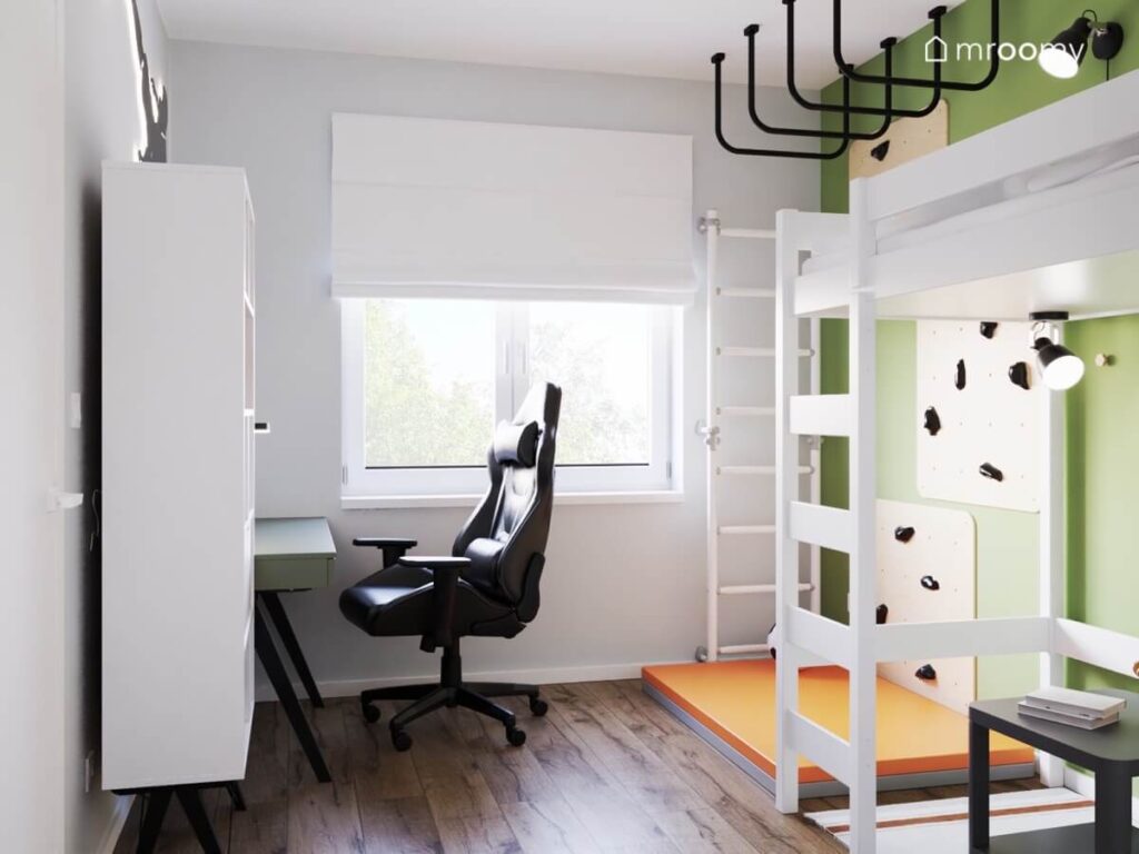 Szaro zielony pokój dla chłopca z białymi meblami drabinką gimnastyczną oraz ścianką wspinaczkową i pomarańczowym materacem
