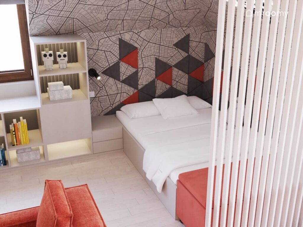 Oddzielona lamelami strefa spania w poddaszowym pokoju dla chłopca z prostym łóżkiem materacem oraz tapetą i trójkątnymi panelami na ścianie
