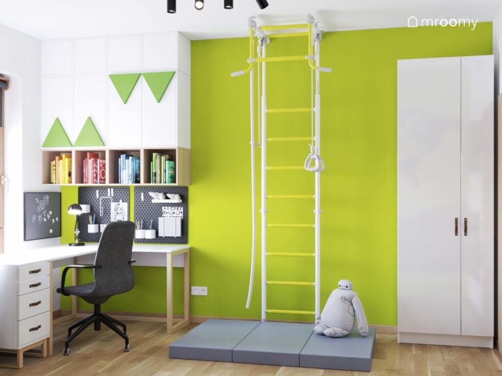 Soczyście zielona ściana w pokoju dla chłopca a na niej drabinka gimnastyczna duża szafa oraz szafki i organizery ścienne
