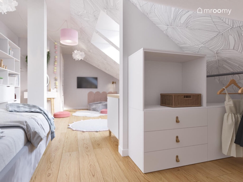 Poddaszowy pokój dla nastolatki a w nim szare łóżko oraz garderoba z białymi meblami