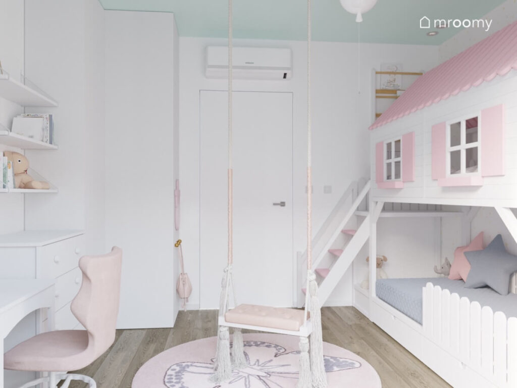 Biały pokój dla dziewczynki z biało różową antresolą w formie domku huśtawką z frędzlami oraz dywanem z motylem