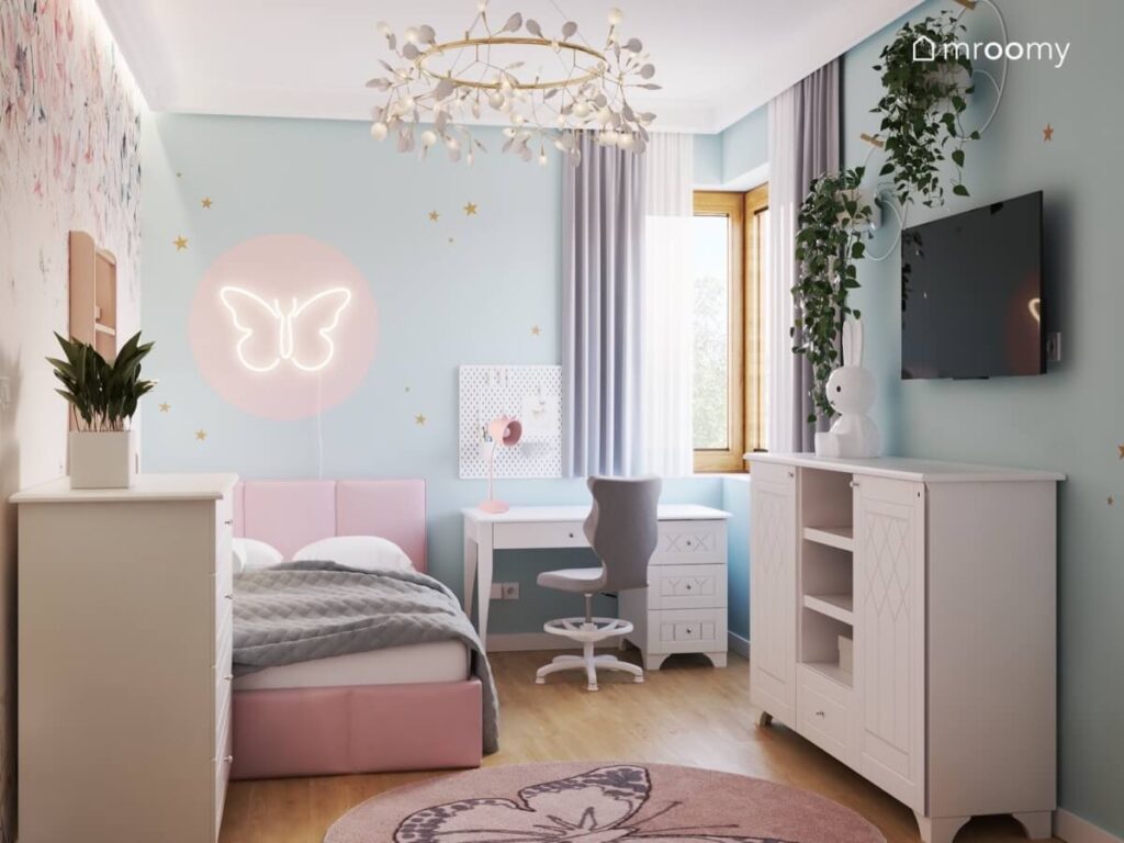 Biało błękitny pokój dla dziewczynki z różowym łóżkiem białym biurkiem i szafką oraz ledonem motyl