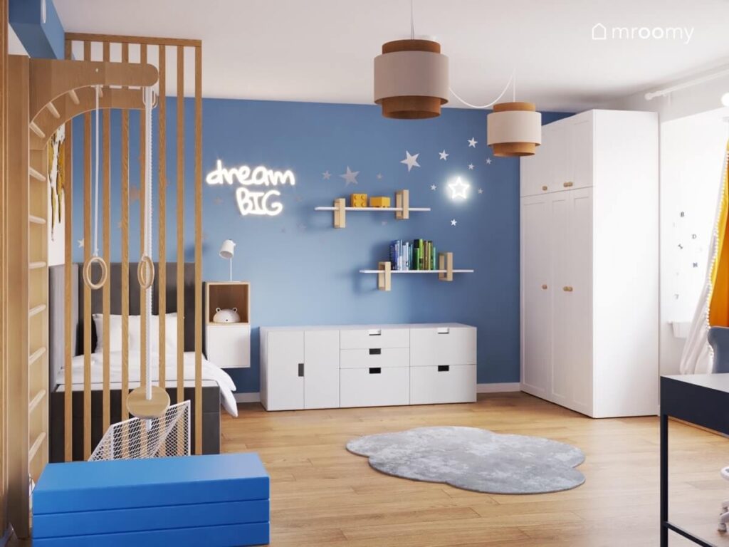 Niebiesko biały pokój dla dziewczynki z białymi meblami drewnianymi lamelami oraz dywanem w kształcie chmurki