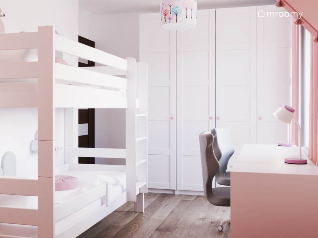 Jasny pokój dla dwóch sióstr z łóżkiem piętrowym dużą białą szafą oraz lampą sufitową z abażurem w drzewa