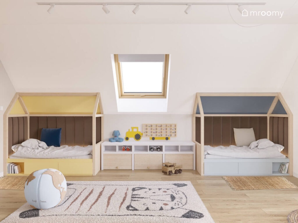 Dwa drewniane łóżka domki uzupełnione brązowymi panelami ściennymi w poddaszowym pokoju dwóch malutkich chłopców