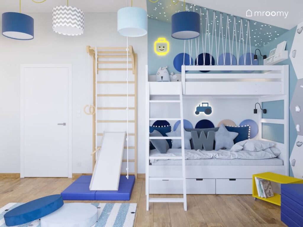Drewniana drabinka gimnastyczna ze zjeżdżalnią a obok łóżko piętrowe z miejscem do zabawy na górze w pokoju dla chłopca