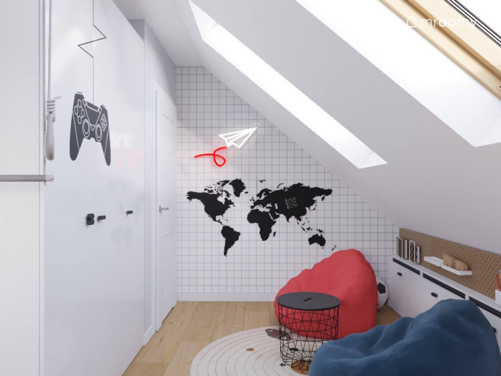 Jasny poddaszowy pokój dla chłopca z dużą białą szafą z naklejką w kształcie pada z dwoma pufami oraz mapą świata i ledonem na ścianie