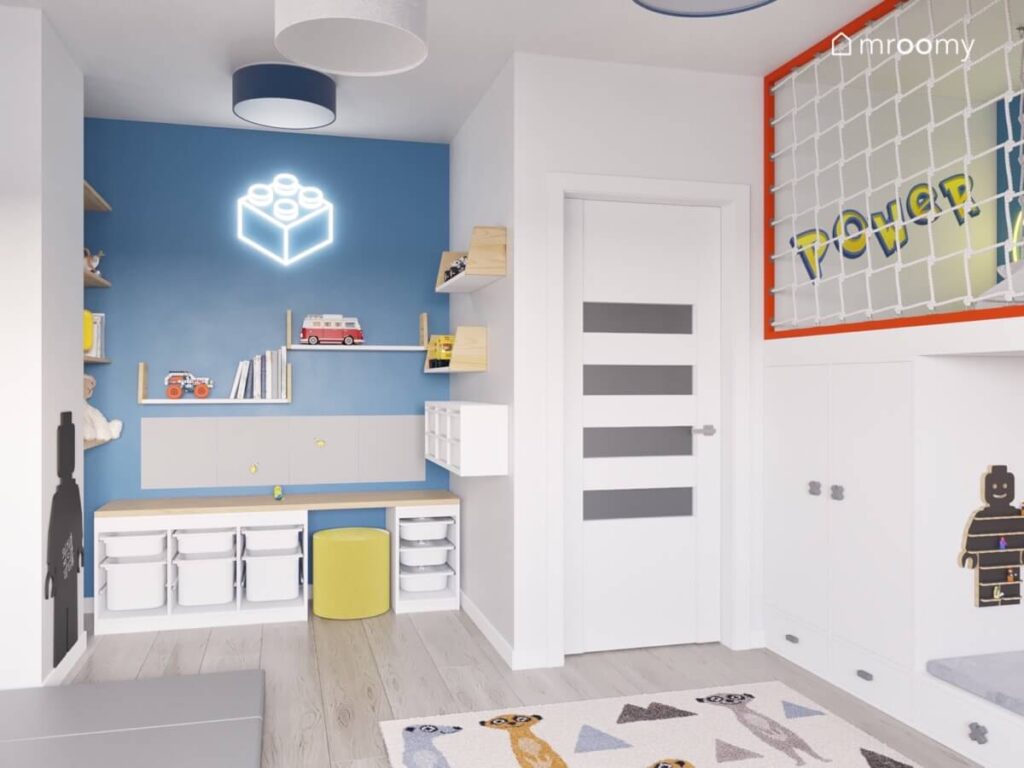Biało niebieski pokój dla chłopca z antresolą regałami z pojemnikami dywanem w surykatki oraz plafonami na suficie