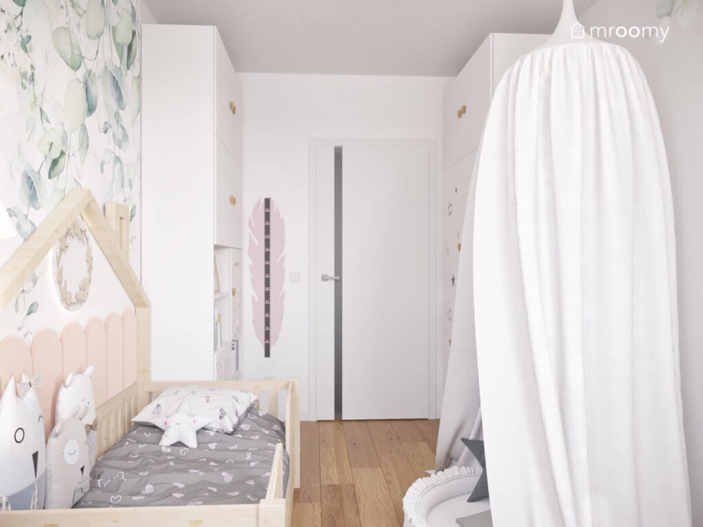 Biały pokój dla dziewczynki a w nim białe meble drewniane łóżko domek oraz gniazdko z baldachimem