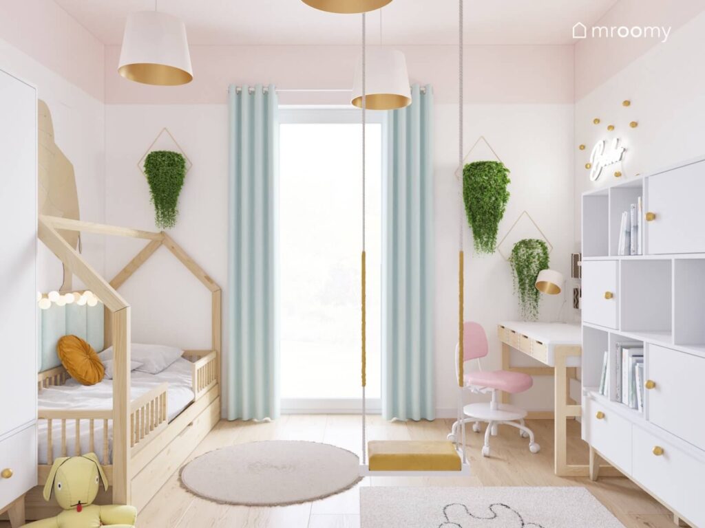 Jasny pokój dla dziewczynki a w nim drewniane łóżko domek huśtawka wisząca oraz ozdobne kwietniki
