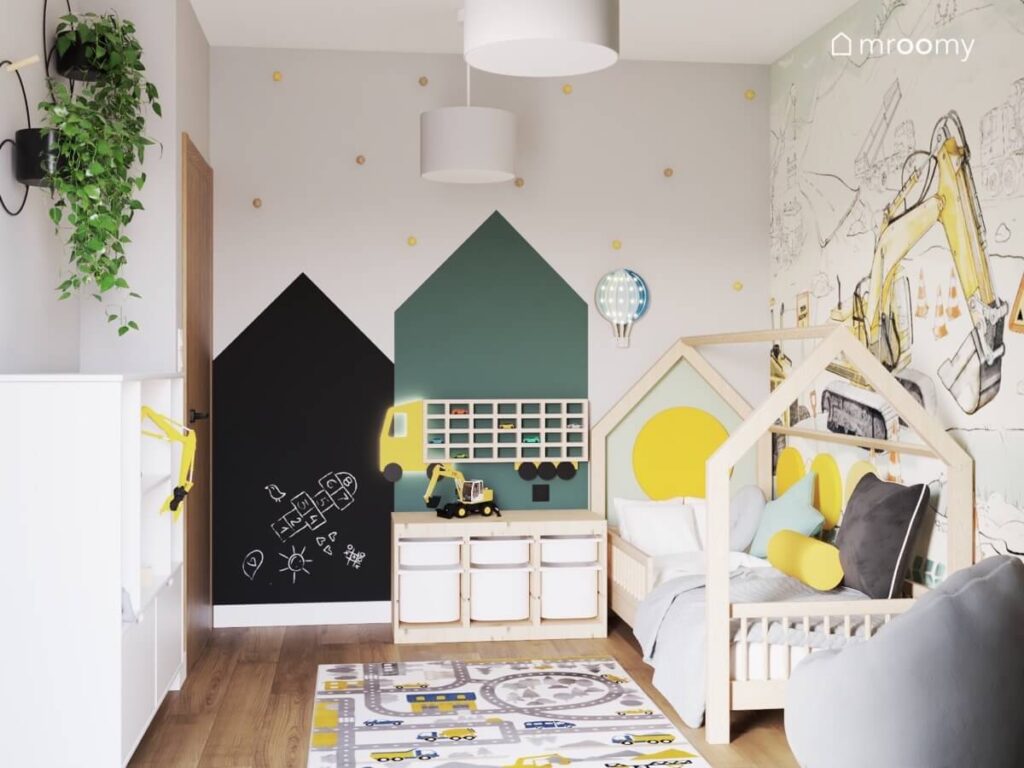 Szary pokój dla chłopca z powierzchnią kredową w kształcie domku drewnianym łóżkiem domkiem oraz dywanem z miastem