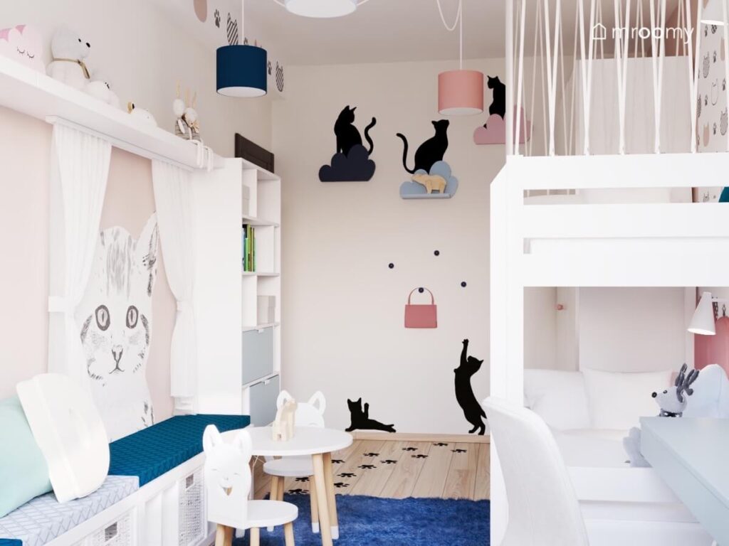 Koci pokój dla dwóch dziewczynek z białym łóżkiem śladami łapek na podłodze półeczkami w kształcie chmurek oraz naklejkami kotami