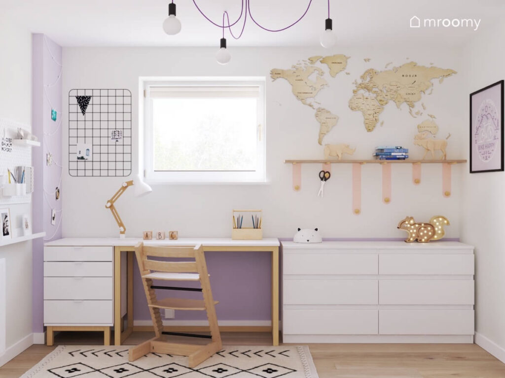 Strefa nauki w pokoju dla dziewczynki w wieku szkolnym a w niej biurko i szafki a na ścianie półka organizer i mapa świata