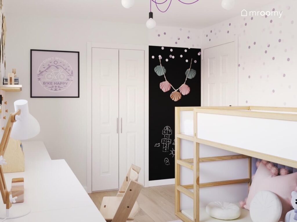 Biały pokój dla dziewczynki z biało drewnianym łóżkiem czarną powierzchnią kredową obrazkiem ściennym girlandą z muszlami oraz kropkami na ścianie