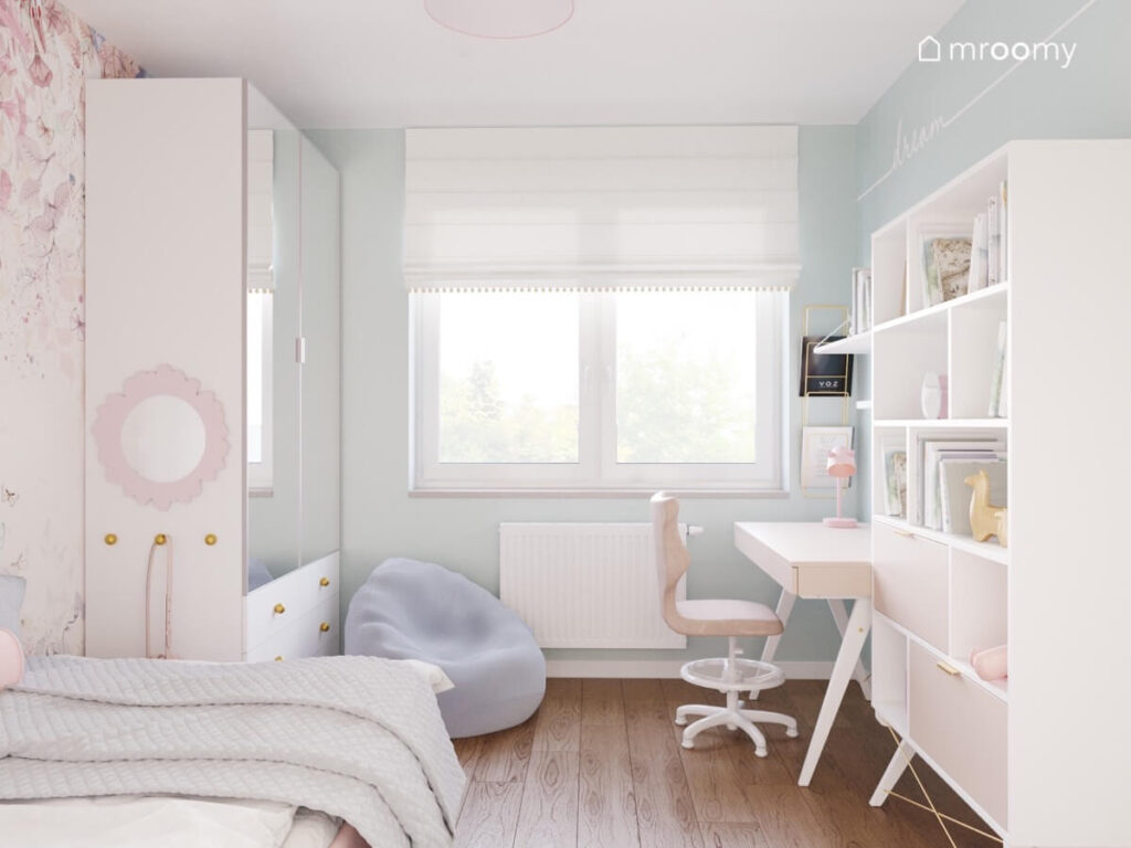 Błękitny pokój dla dziewczynki z różowym tapicerowanym łóżkiem oraz białymi meblami