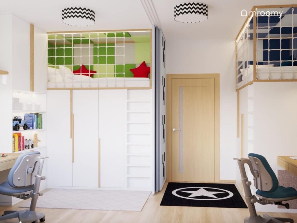 Dwie wyłożone panelami ściennymi antresole z miejscem do spania w pod nimi szafy w białym pokoju dwóch chłopców