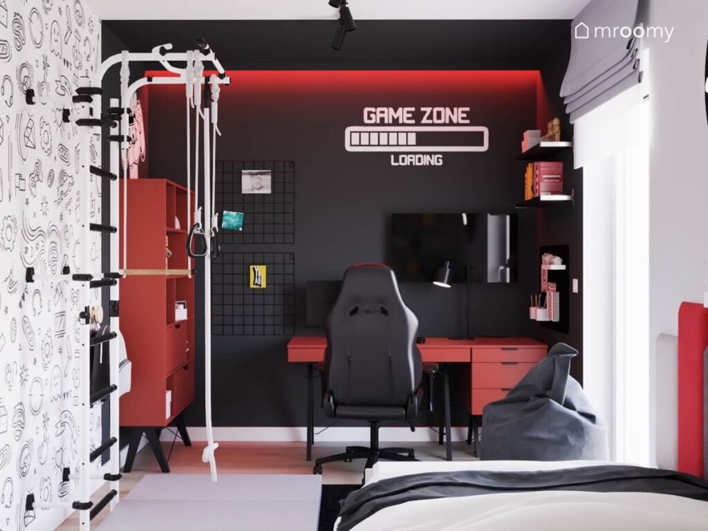 Strefa gamingowa w pokoju dziewięciolatka a w niej czerwone biurko z fotelem gamingowym telewizor czerwony regał organizery oraz tematyczne naklejki