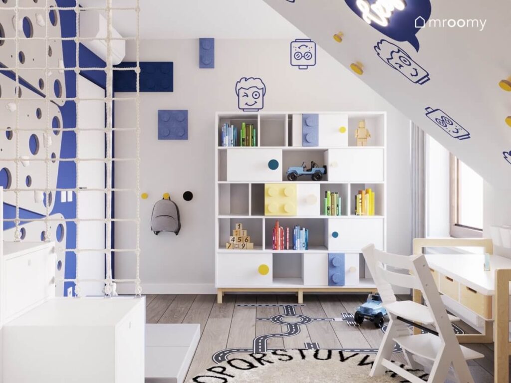 Szaro niebieski poddaszowy pokój dla chłopca z białym regałem oraz licznymi motywami Lego