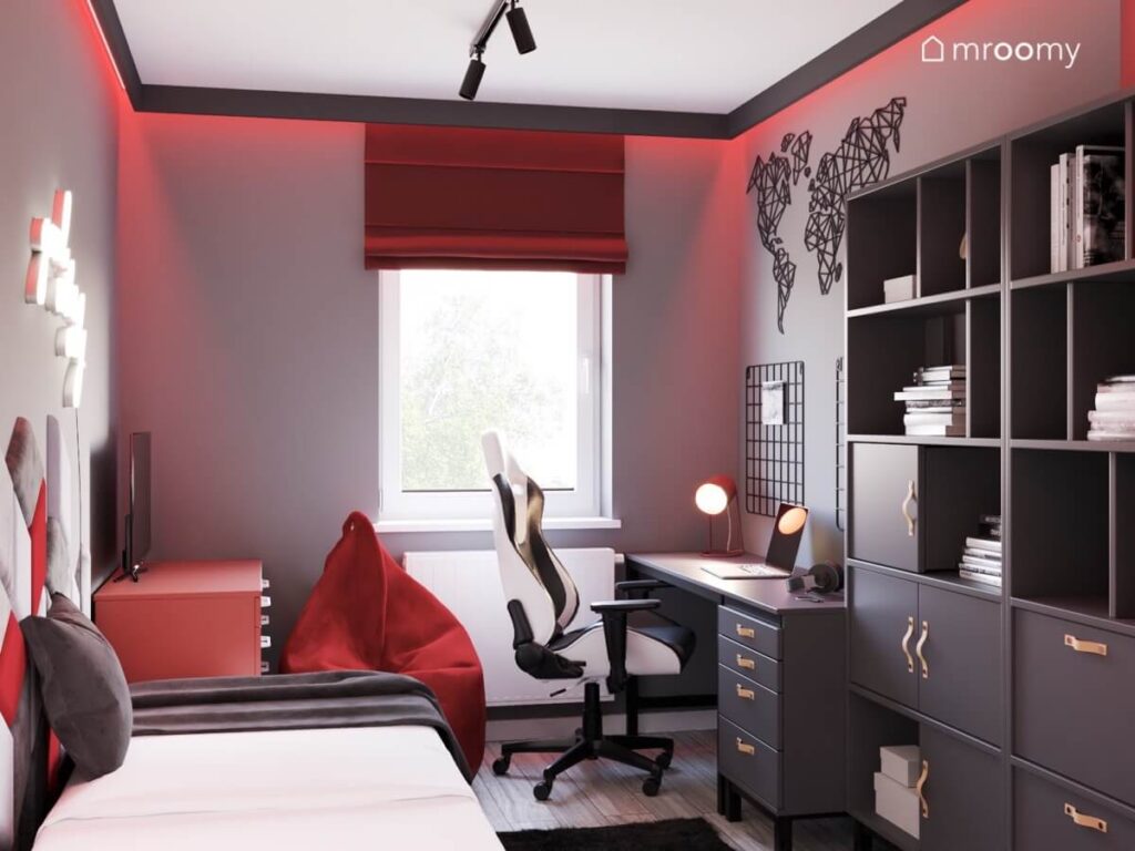 Pokój dla nastolatka z szarymi ścianami podświetlonymi czerwienią szarymi meblami oraz czerwoną pufą